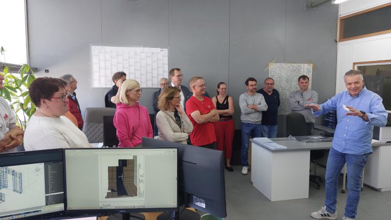 Unternehmensvorstellung Sokol Küchen Hausen Eine Gruppe von Personen hört einem Referenten in einem Büro zu.